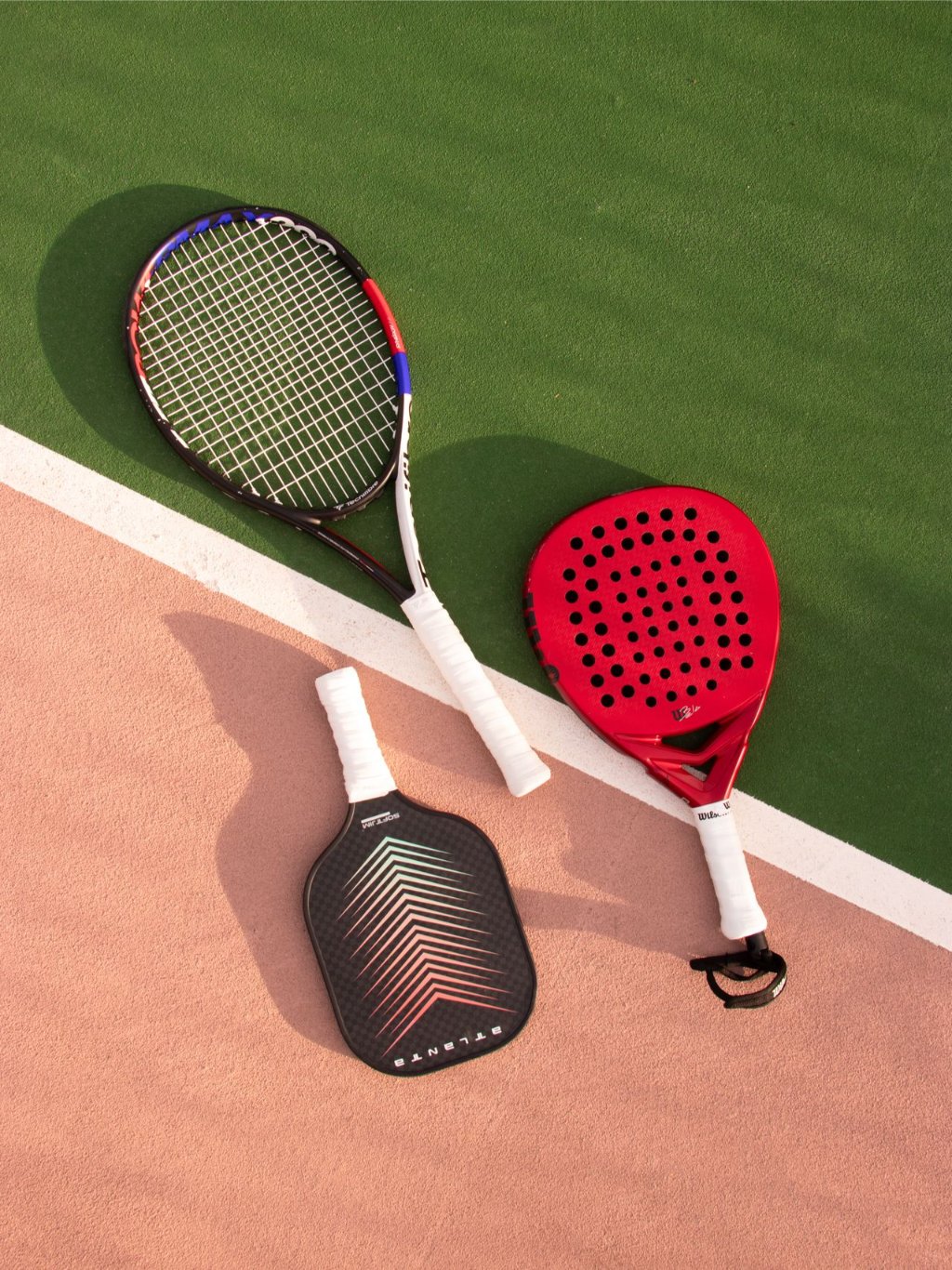 A padel racket alongside a tennis racket, showing the difference in design