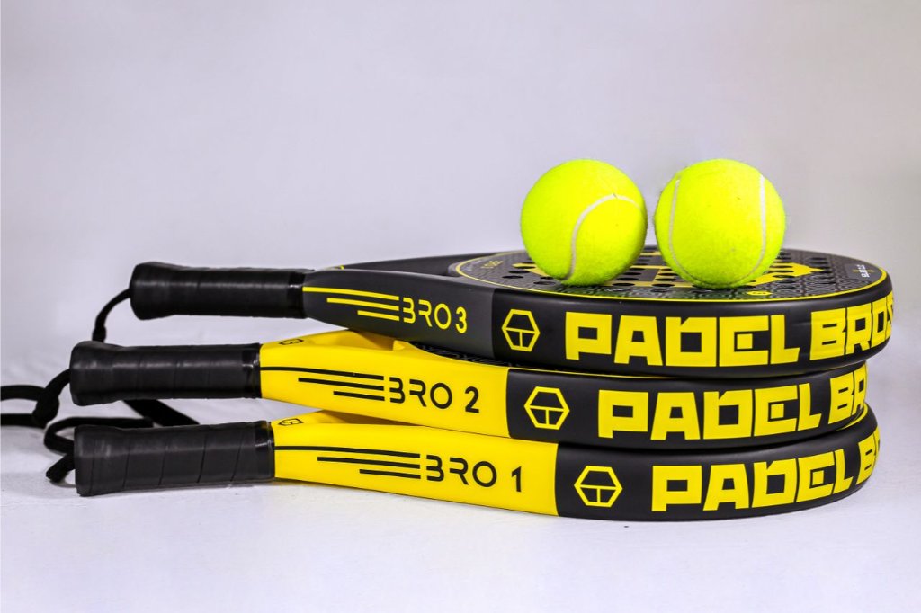A selection of padel rackets with balls on a white background